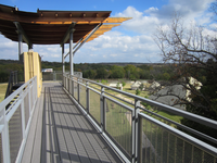 A metal railing on a walkway surrounded by trees.