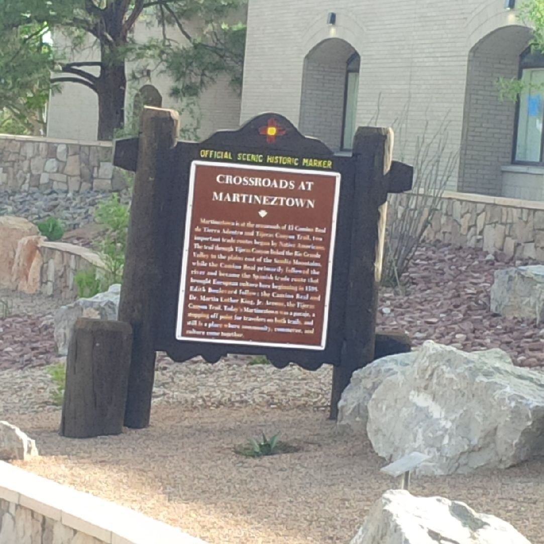 A sign in front of a building with rocks in front of it.