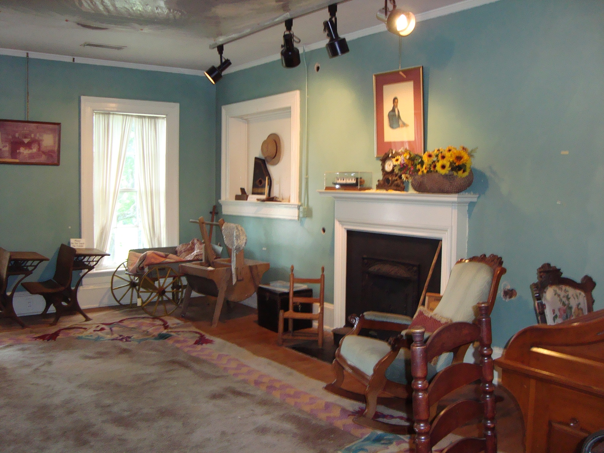 A cozy room with vintage furniture, a fireplace, and light blue walls.