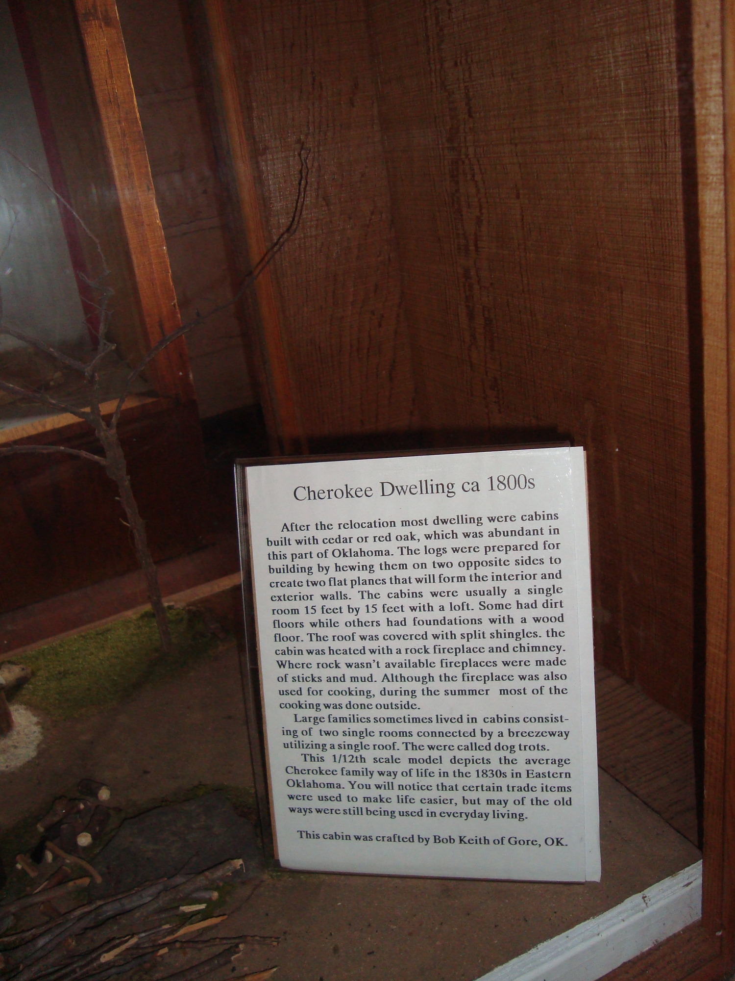 A wooden display case with a sign on it with some text.