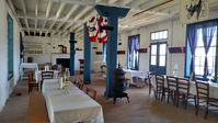 A wooden floor, some chair and tables in a room.