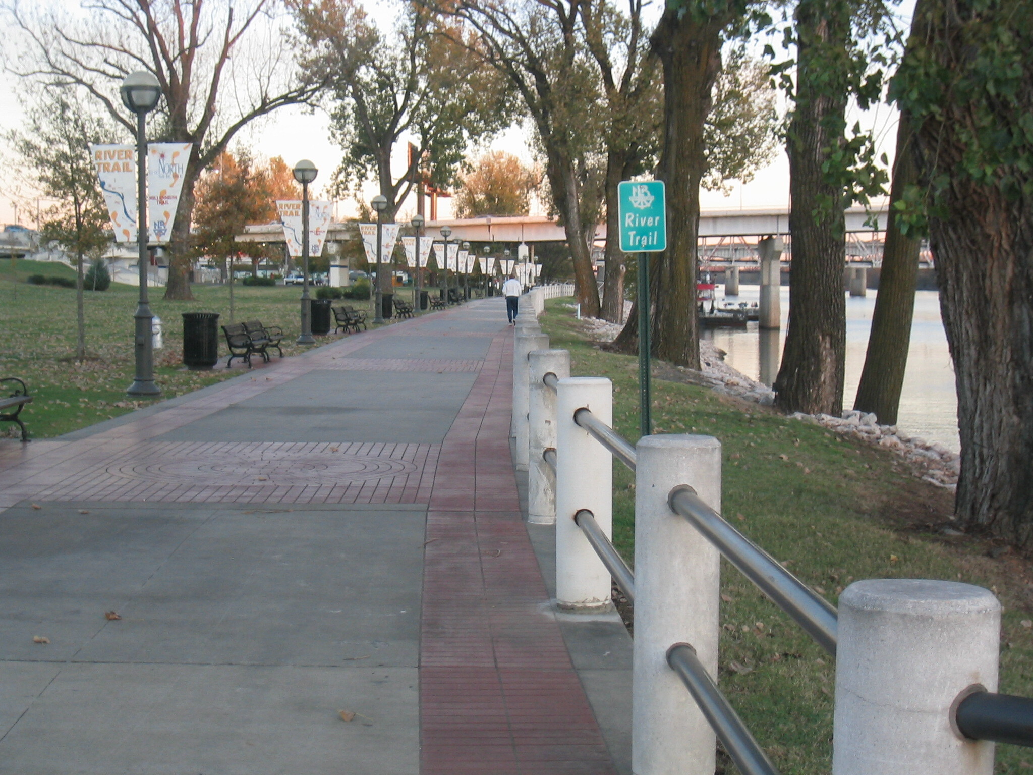 A sidewalk next to a body of water.