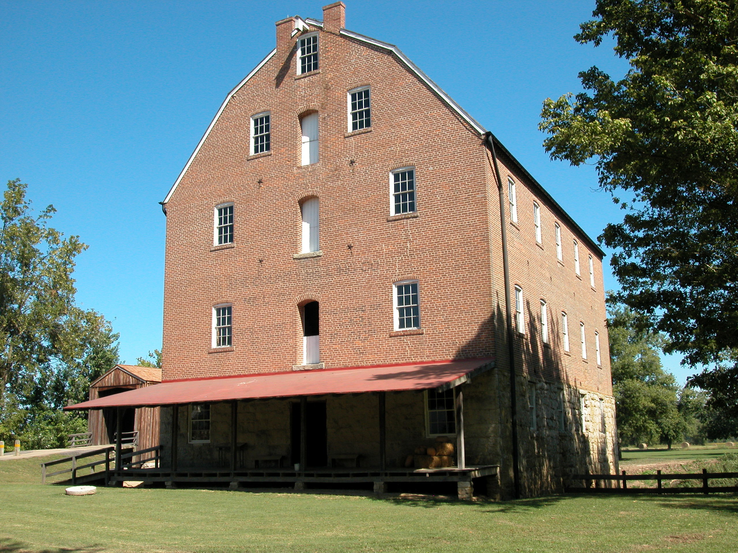 A large brick building in grassy area.