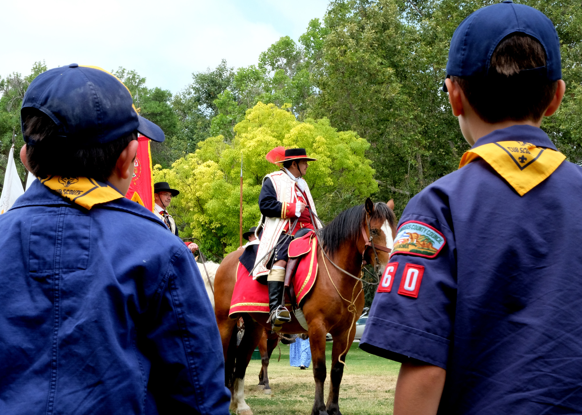 Two Cub Scouts look at Anza on horseback. 