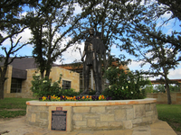 A statue of a man in front of a house.