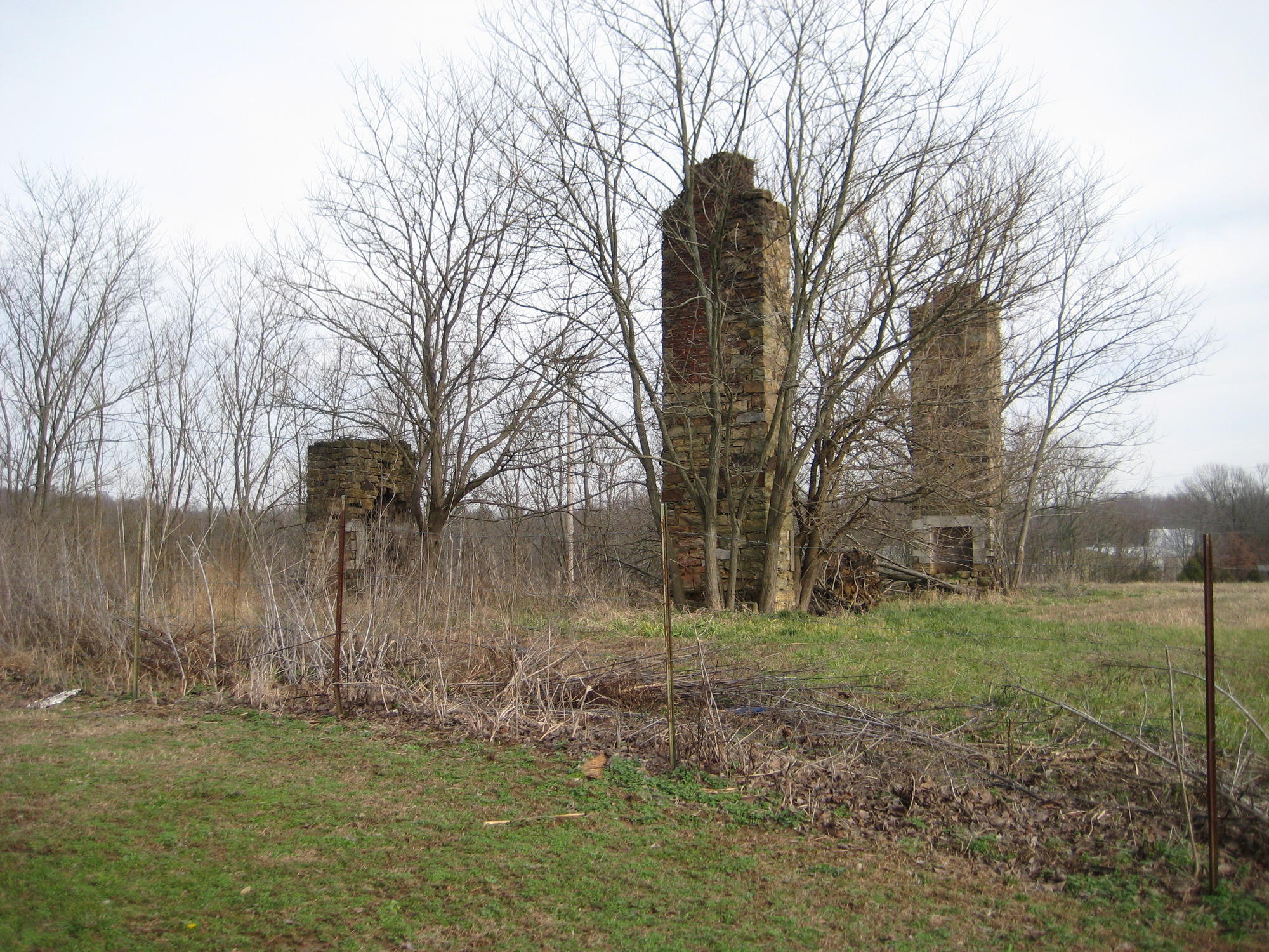 Some brick chimneys in a field.