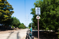 Anza trail marker below a bikes yield to peds sign along a dirt trail