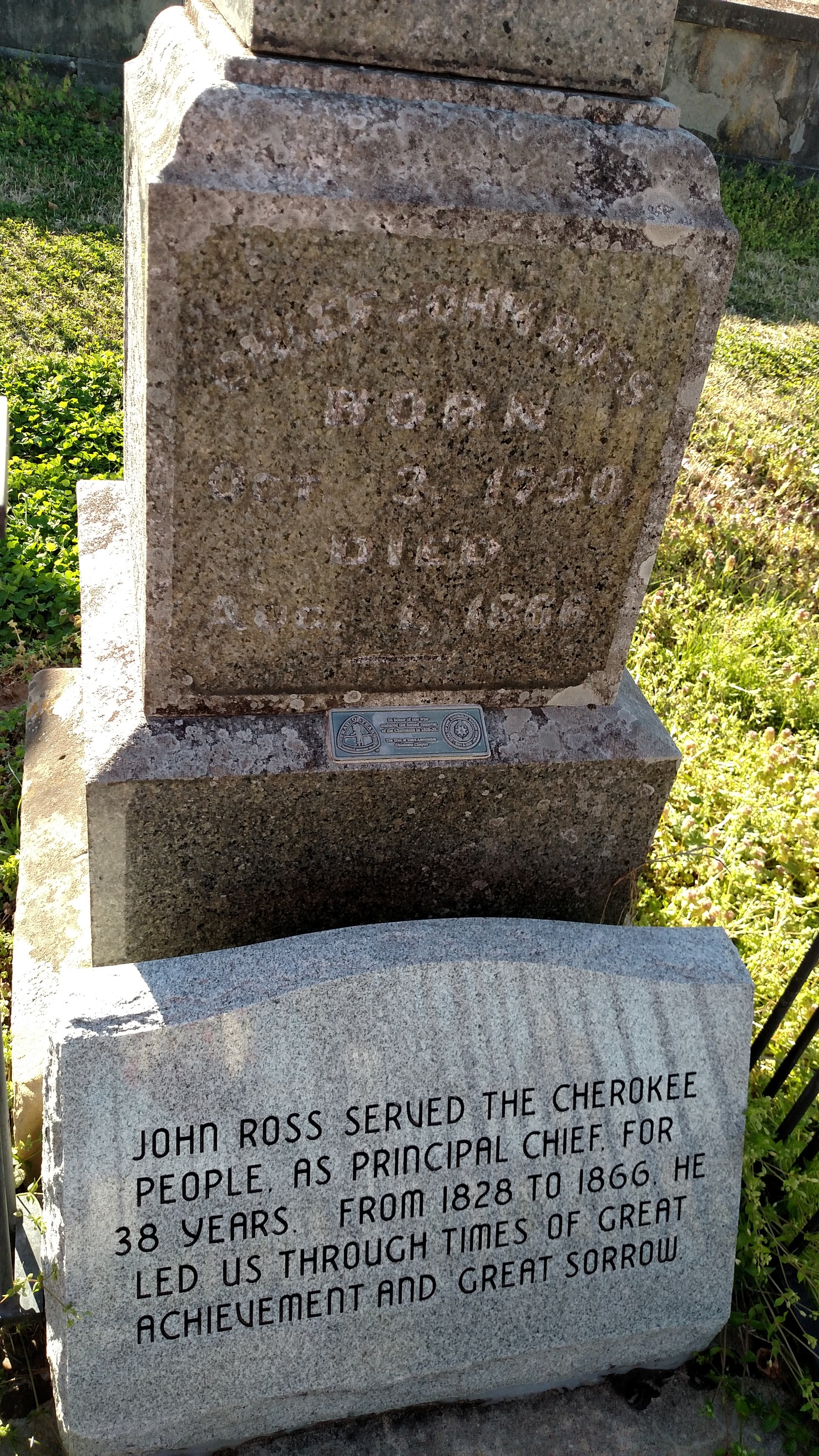 A gravestone with a plaque on it.