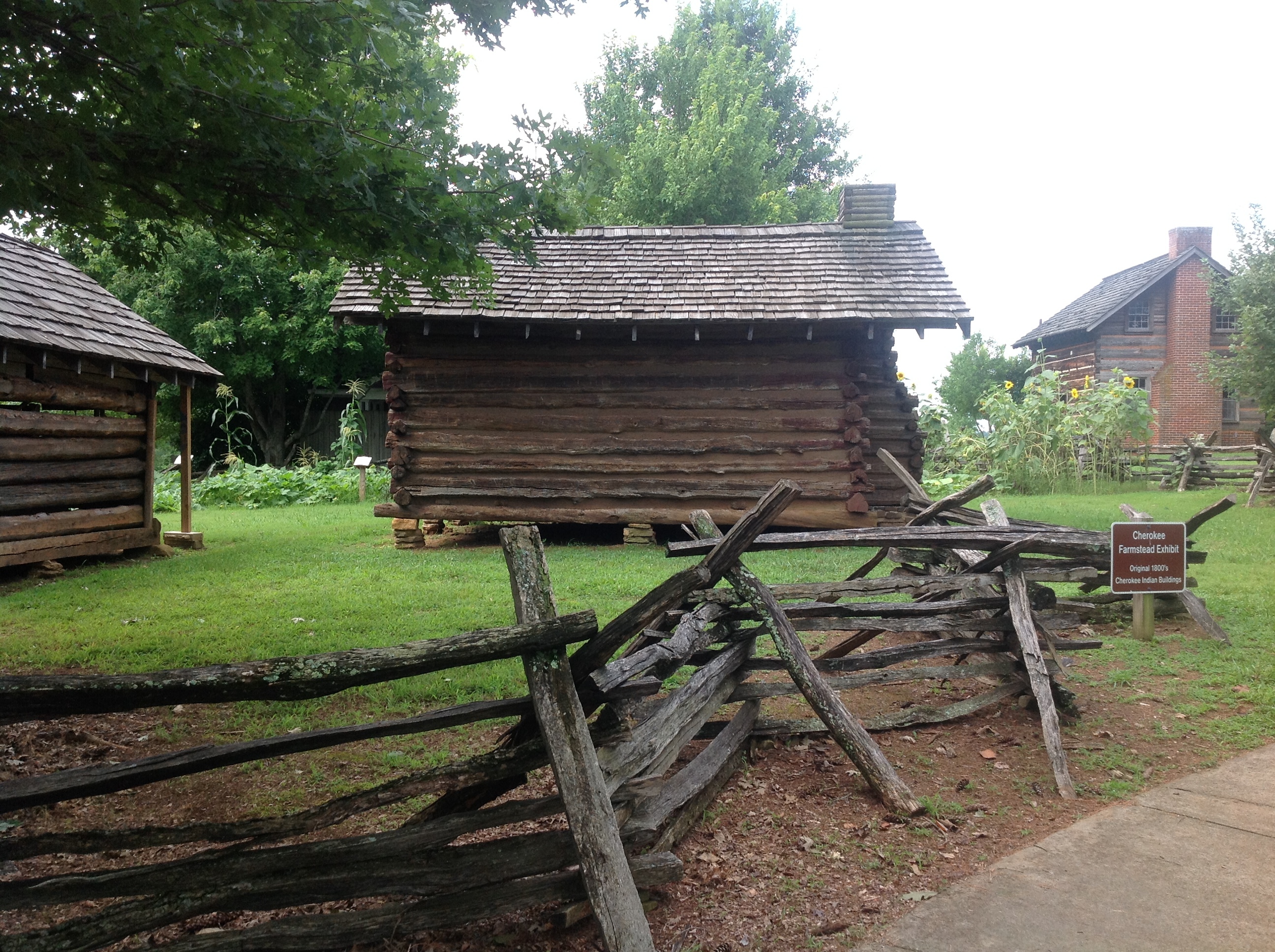 A wooden fence with some hut behind it.