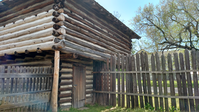 A log cabin with a wooden fence.