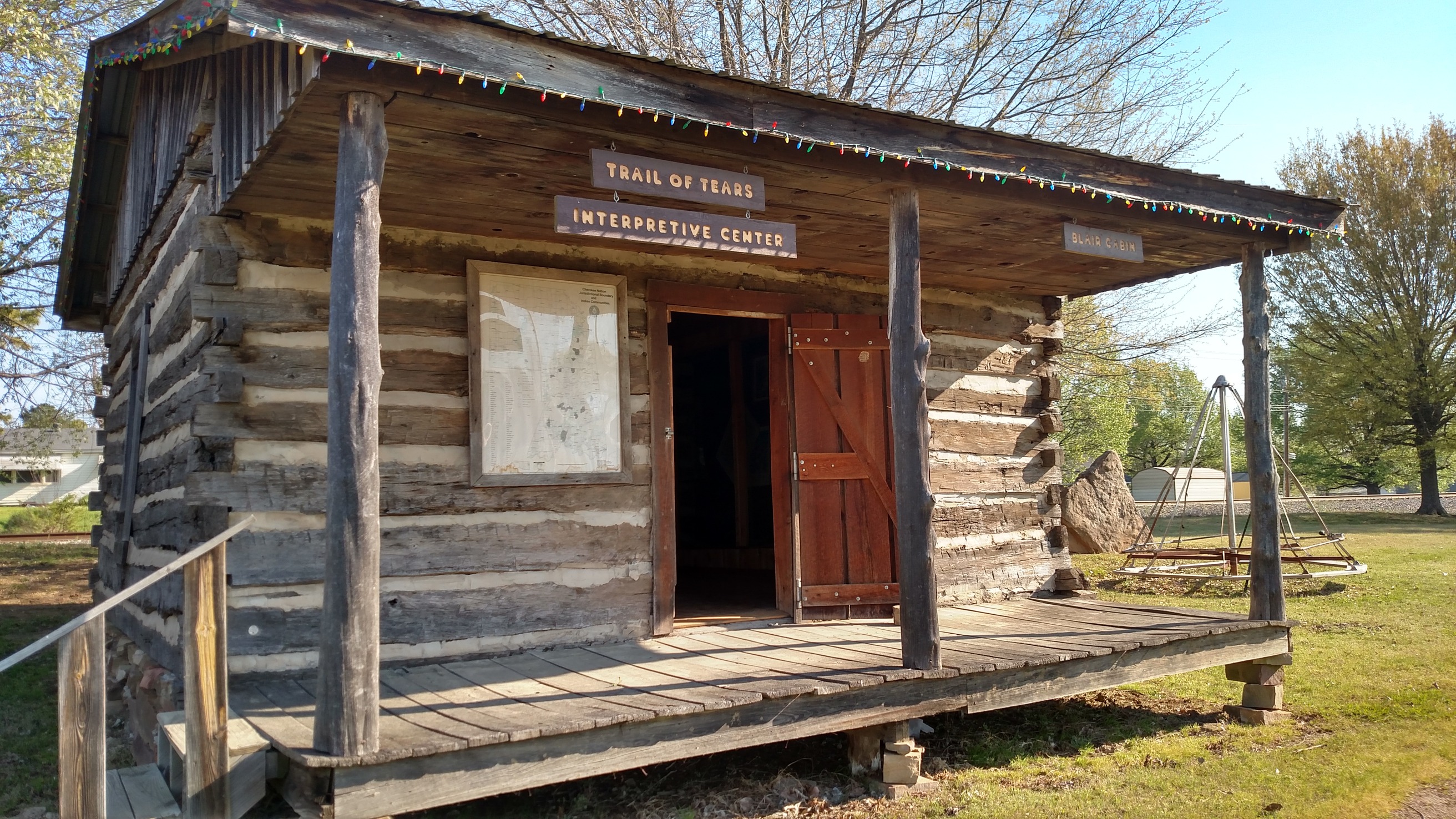 A small log cabin on a grassy area.