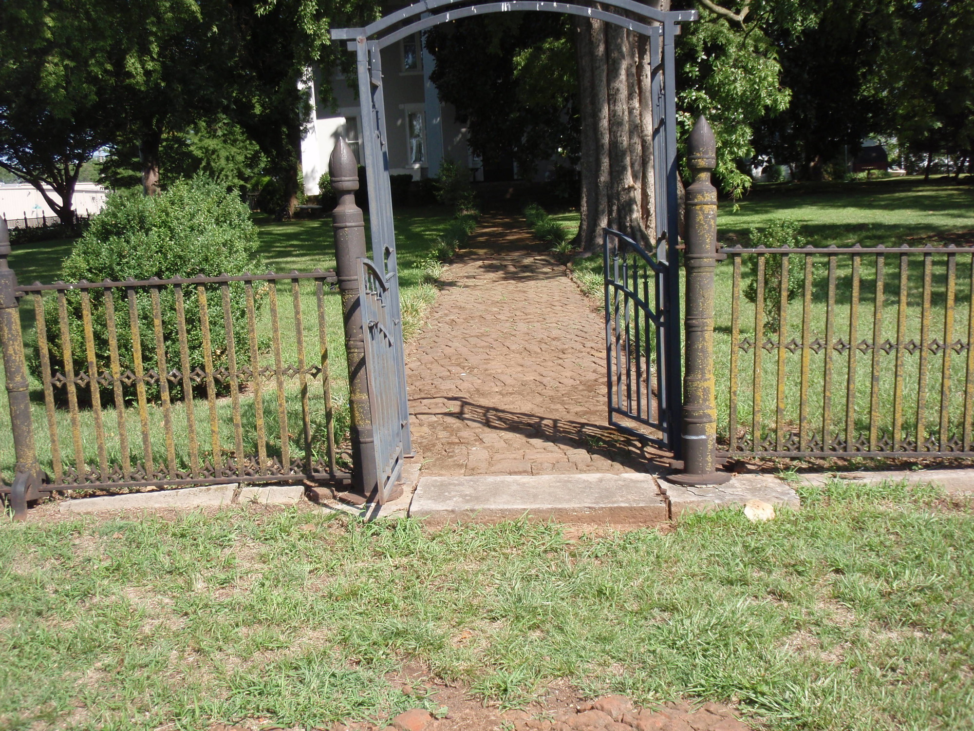 An iron gate leading to a grassy area.