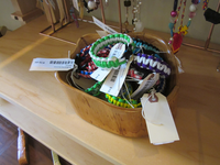 A wooden box filled with bracelets.