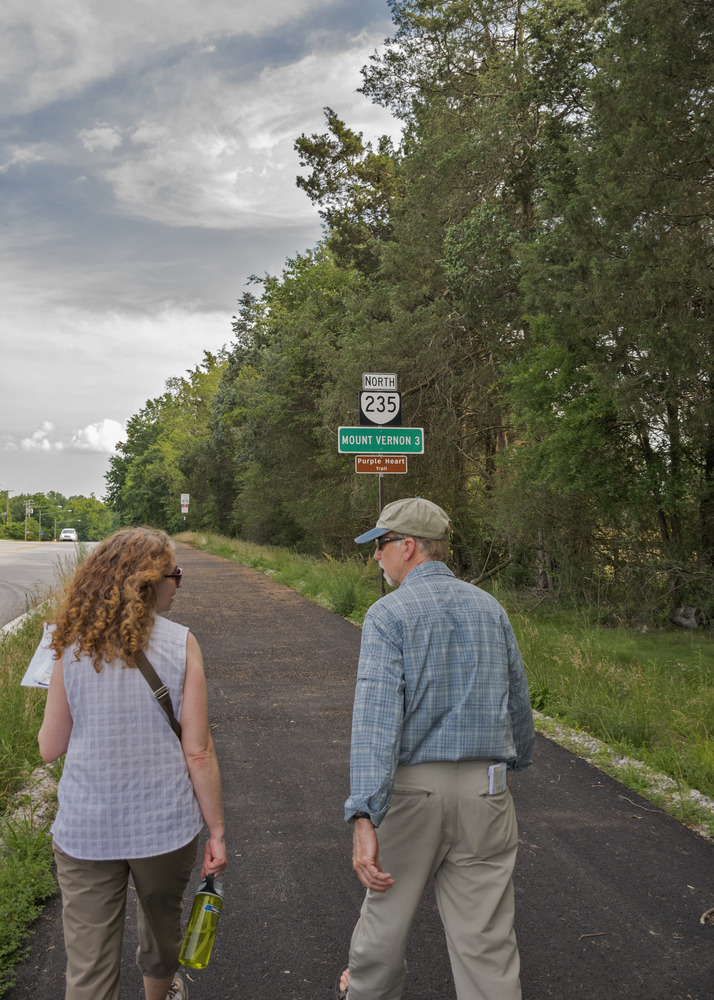 Two people walking along Route 235 on their way to Mount Vernon