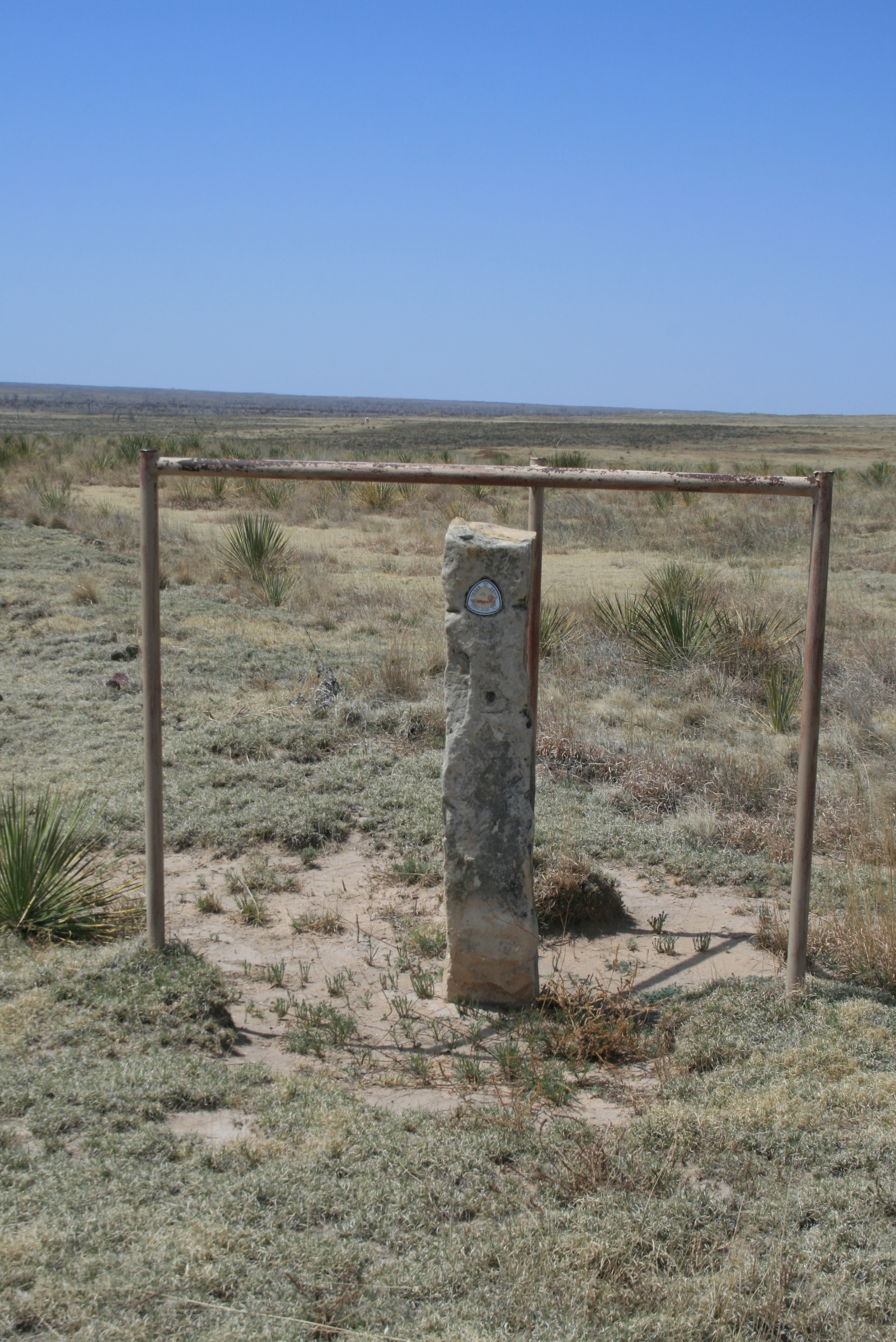 A stone marker in the middle of a field.
