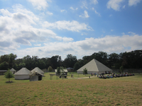 Some small houses in a grassy field.