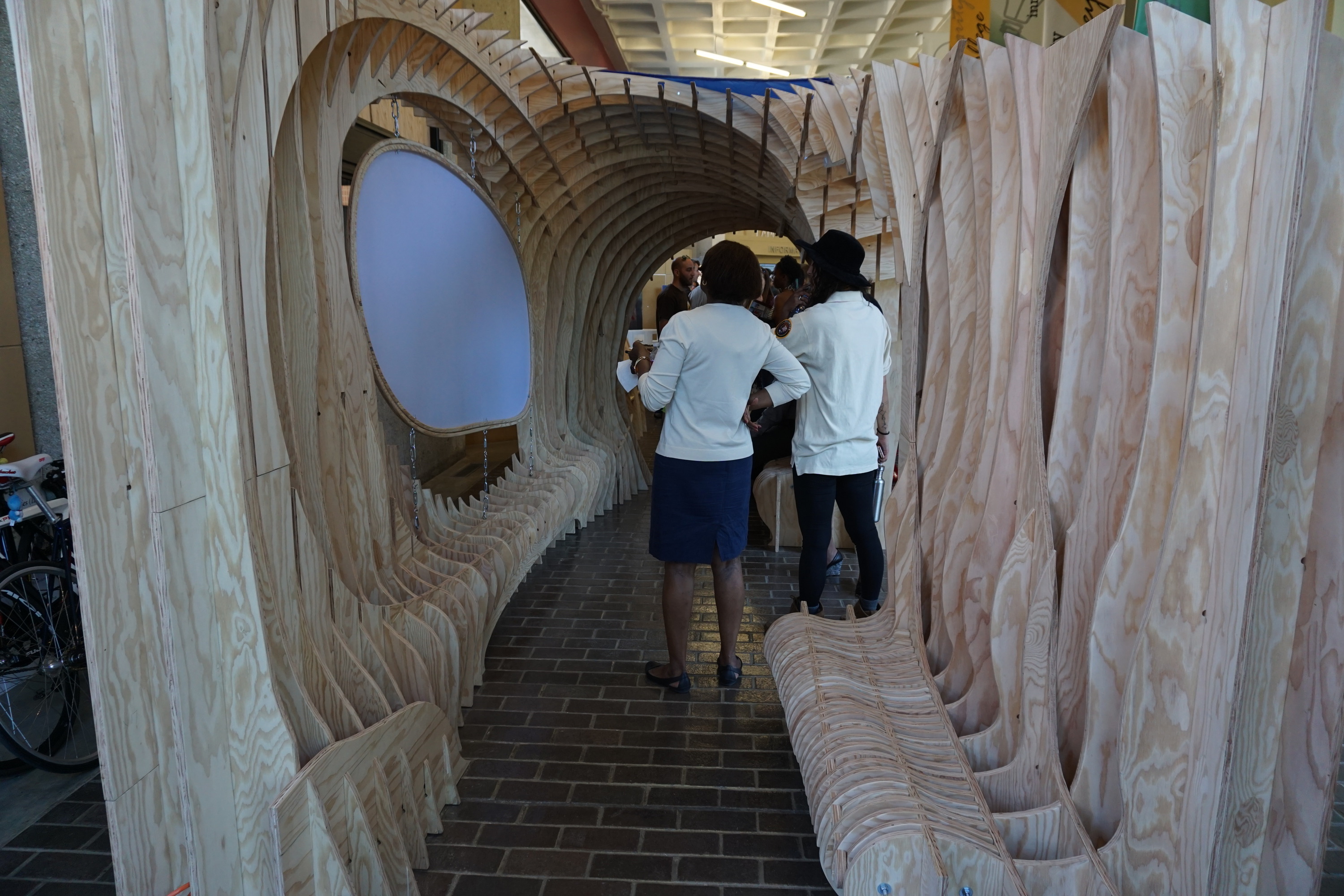 Two people stand inside the parklet watching a film