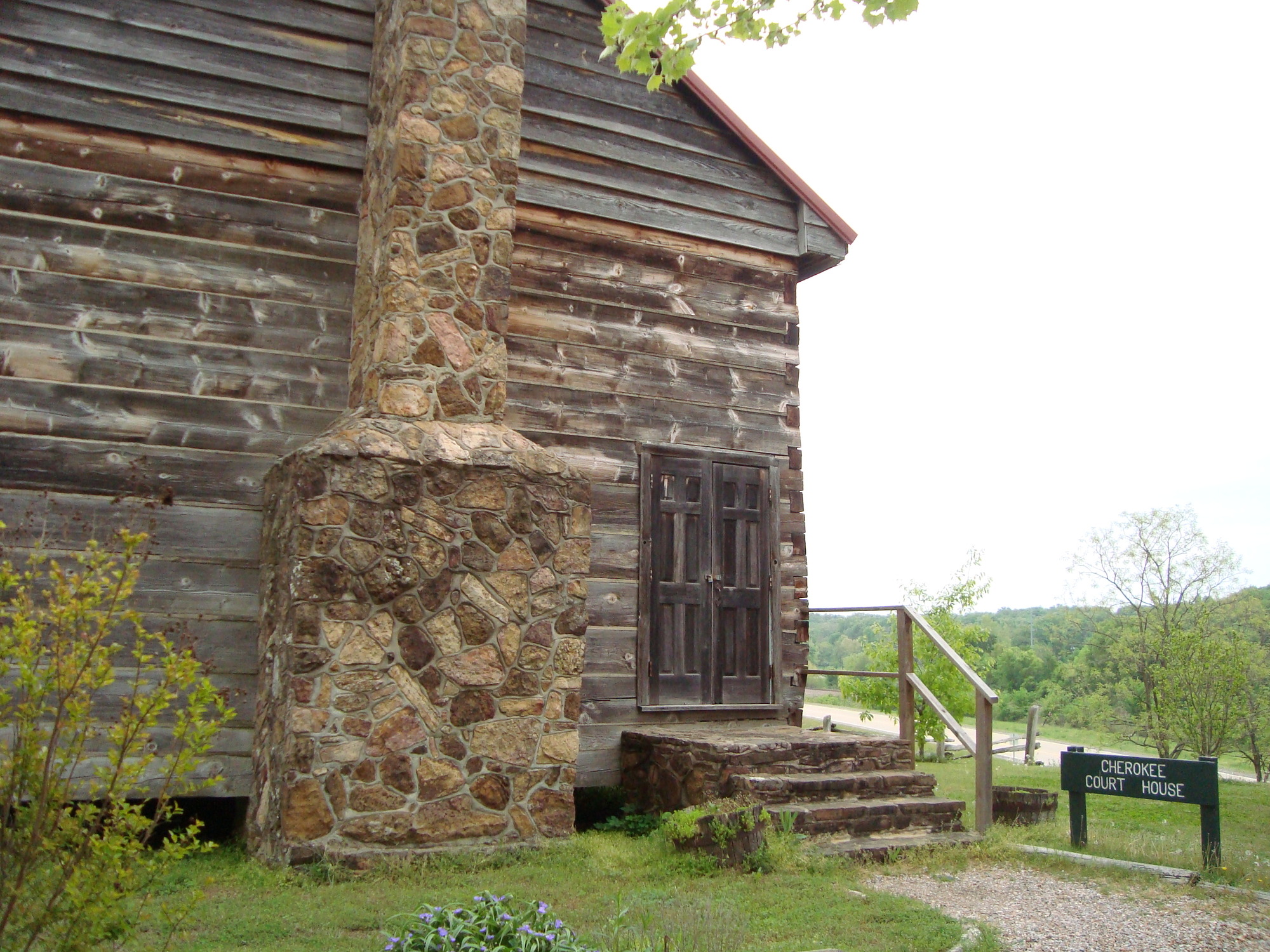 A wooden building with a stone chimney.