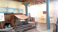 A room with a wooden boat and other items on display.