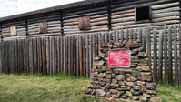 A log cabin with a sign in front of it.