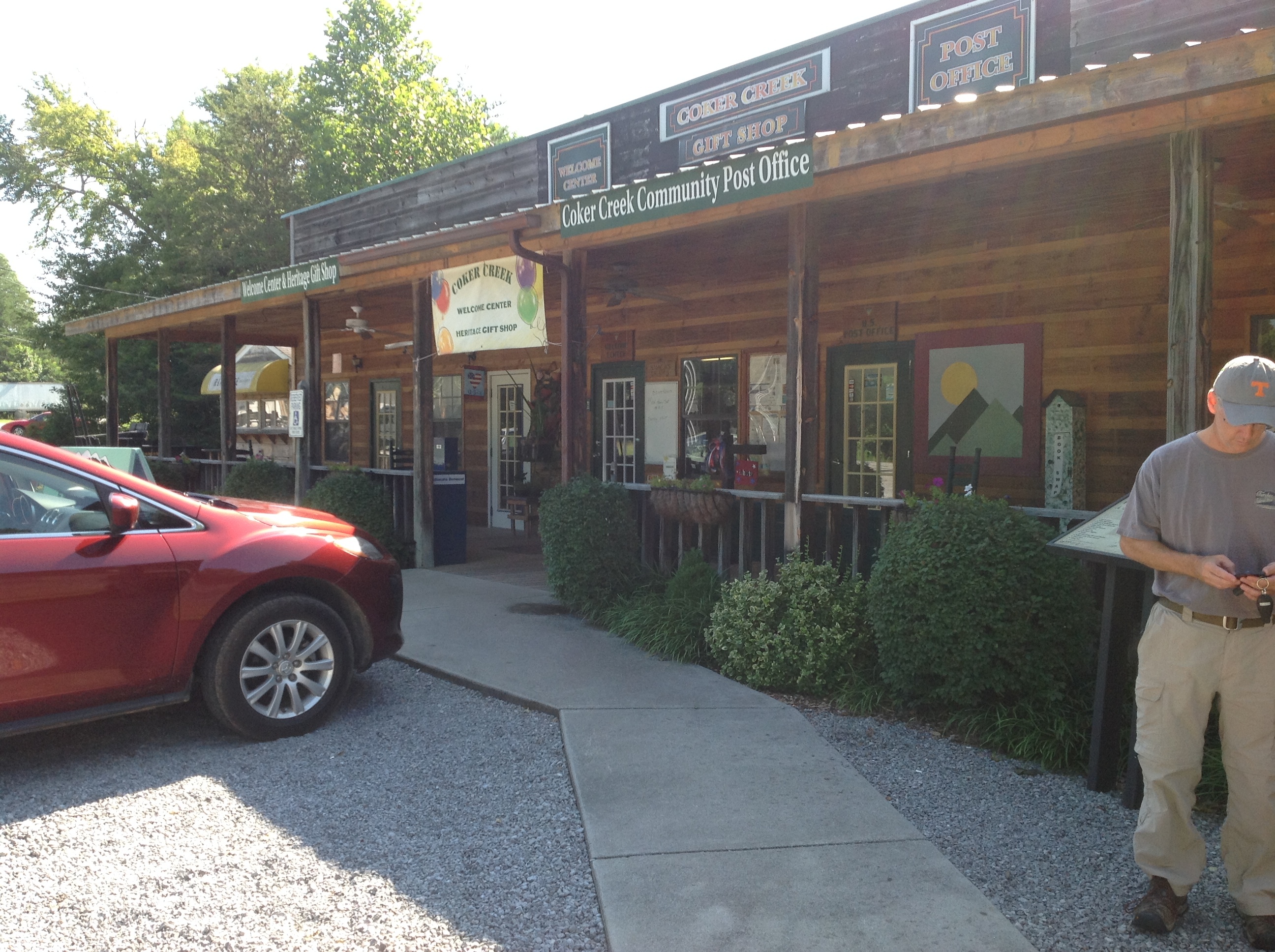 A red car parked in front of a store.