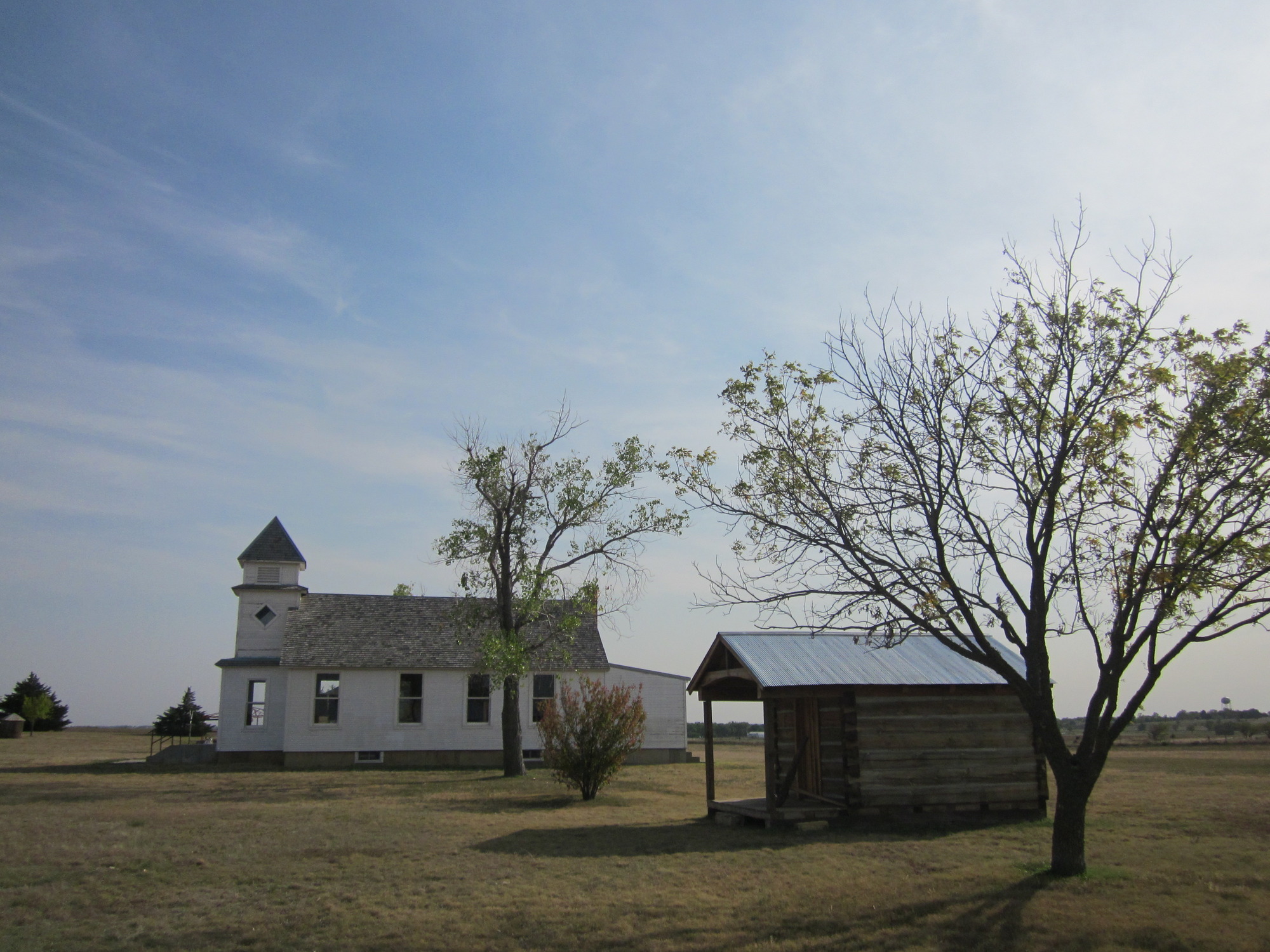 Two houses next to each other in the middle of a field.