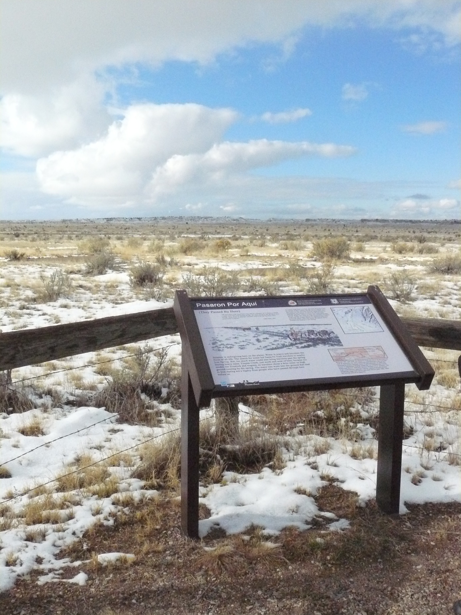 A sign titled "Passron Por Aqur" in the middle of a snowy field.