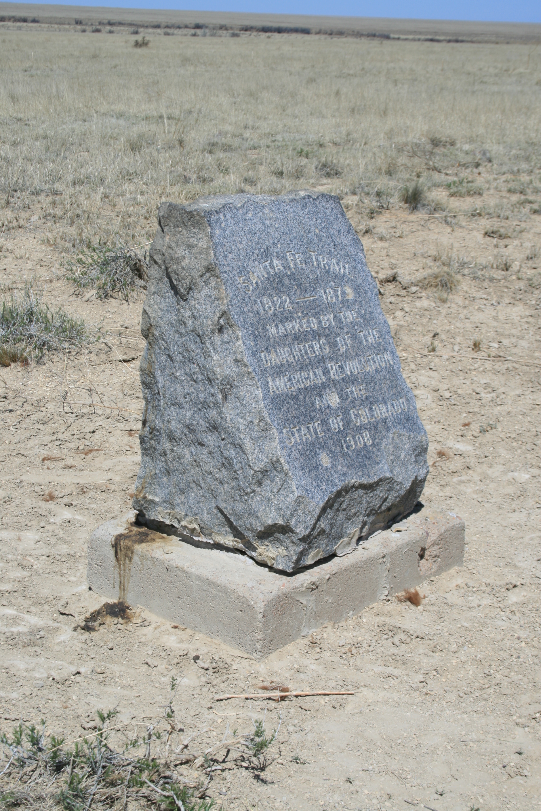 A stone marker in the middle of a field.