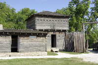 A wooden building wih trees in the background.