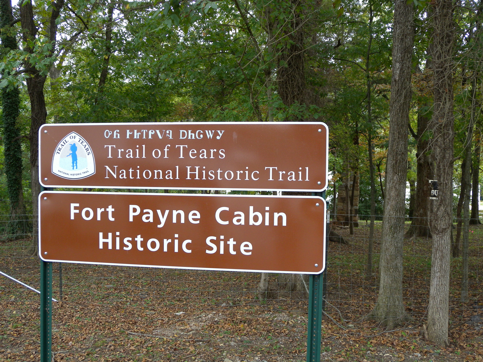 A sign with the text "trail of tears national historical site and fort payne cabin historic site" on it.