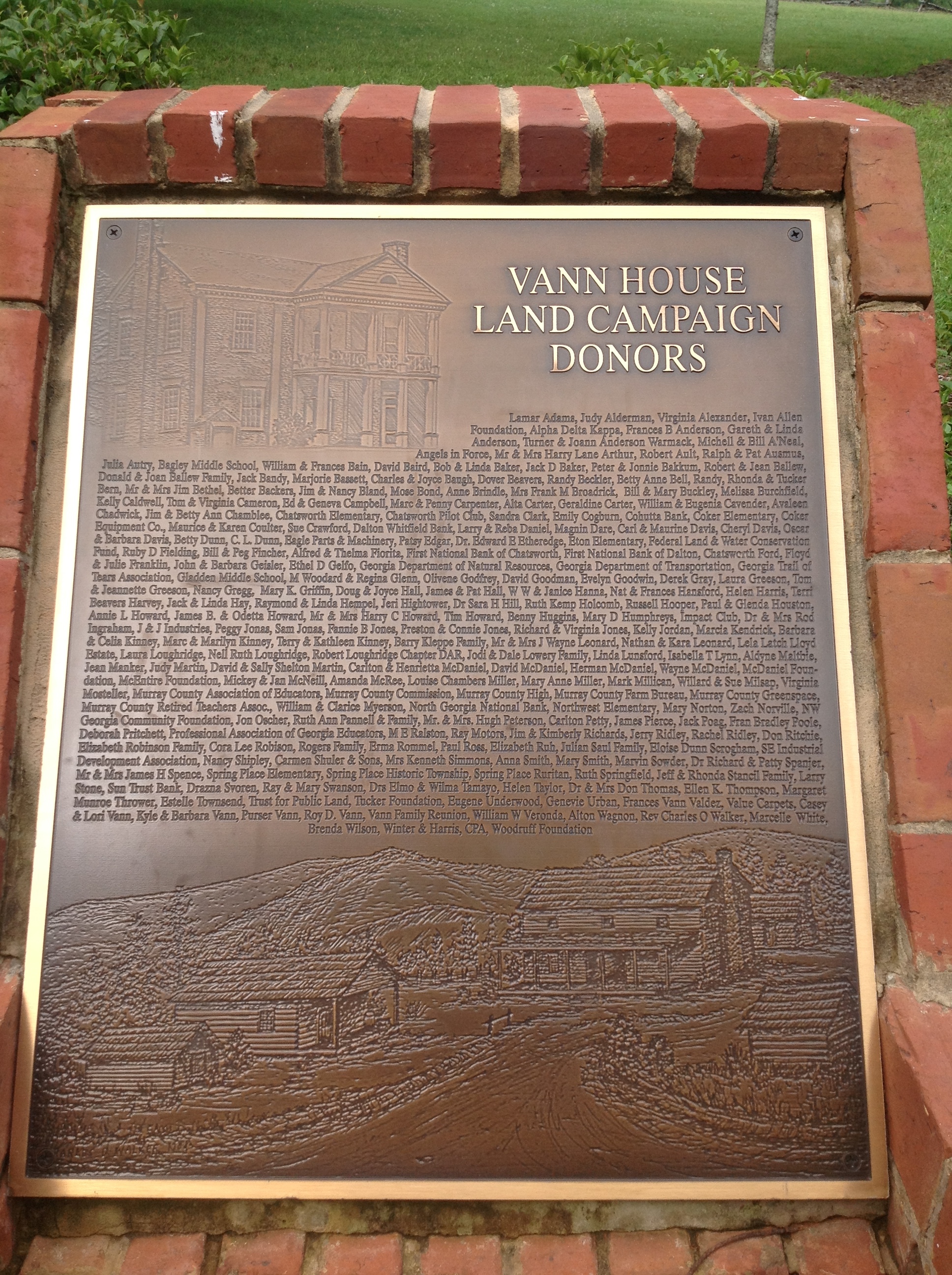 A plaque on a brick wall.