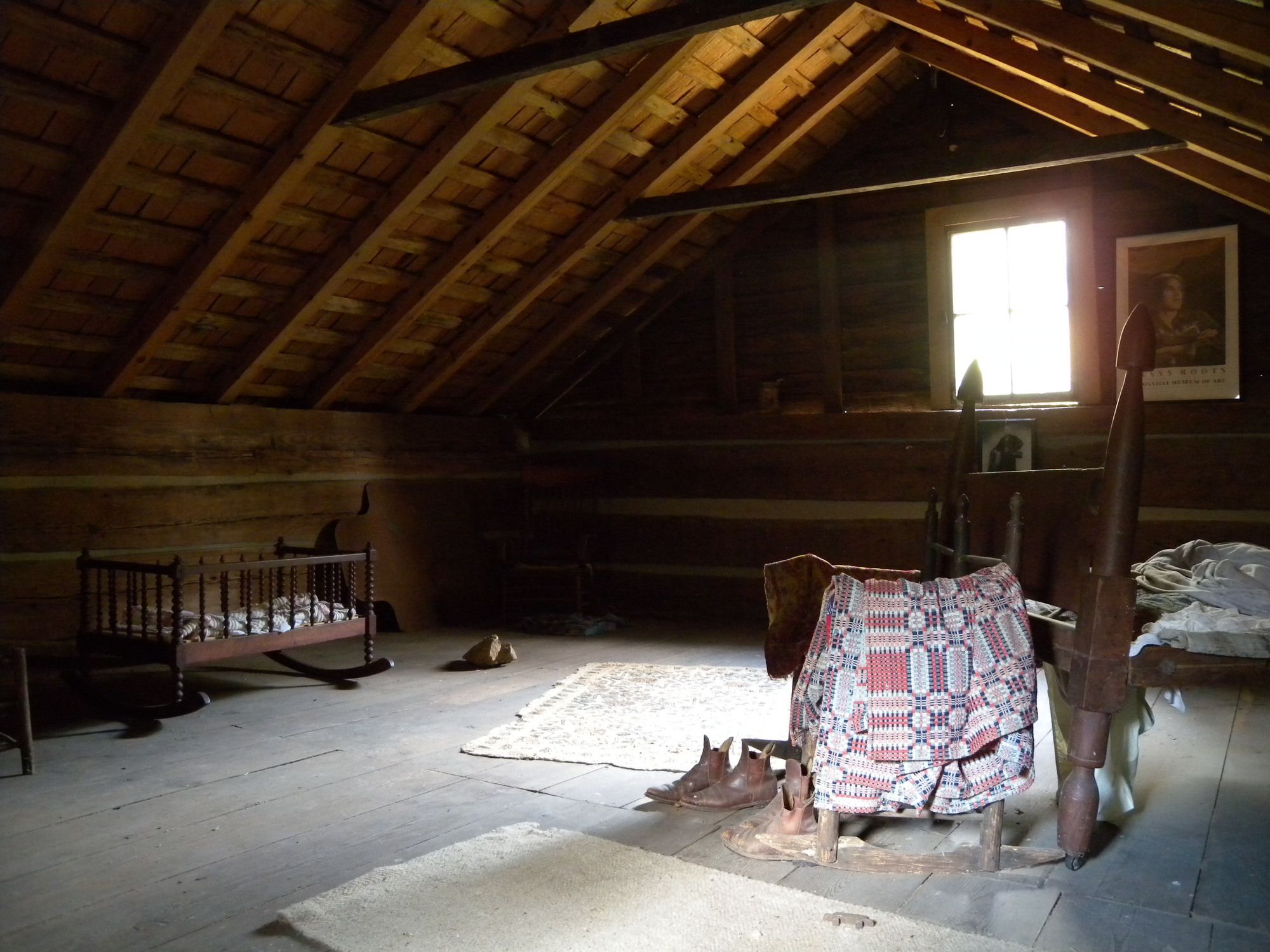 A room in a log cabin with a bed and a crib.