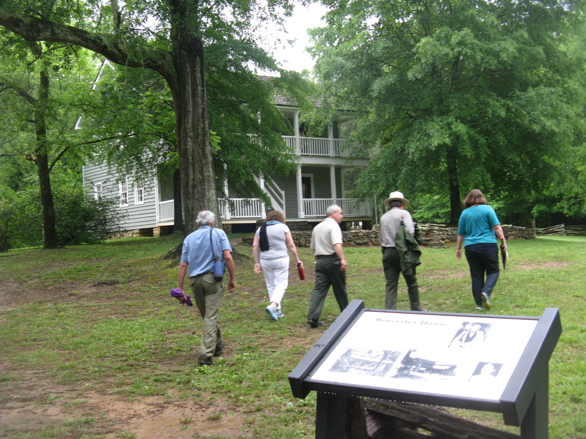A group of people walking in front of a house.