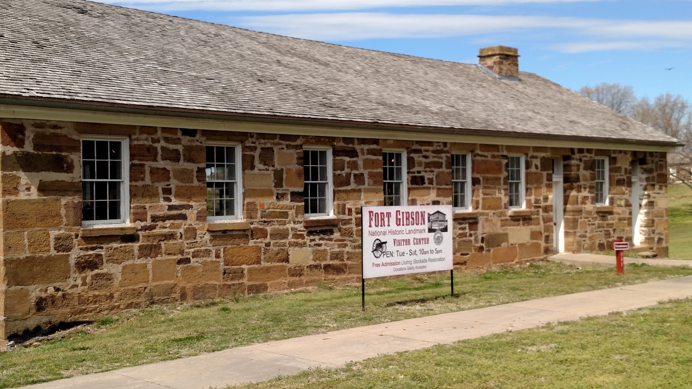 An old house with a sign in front of it.