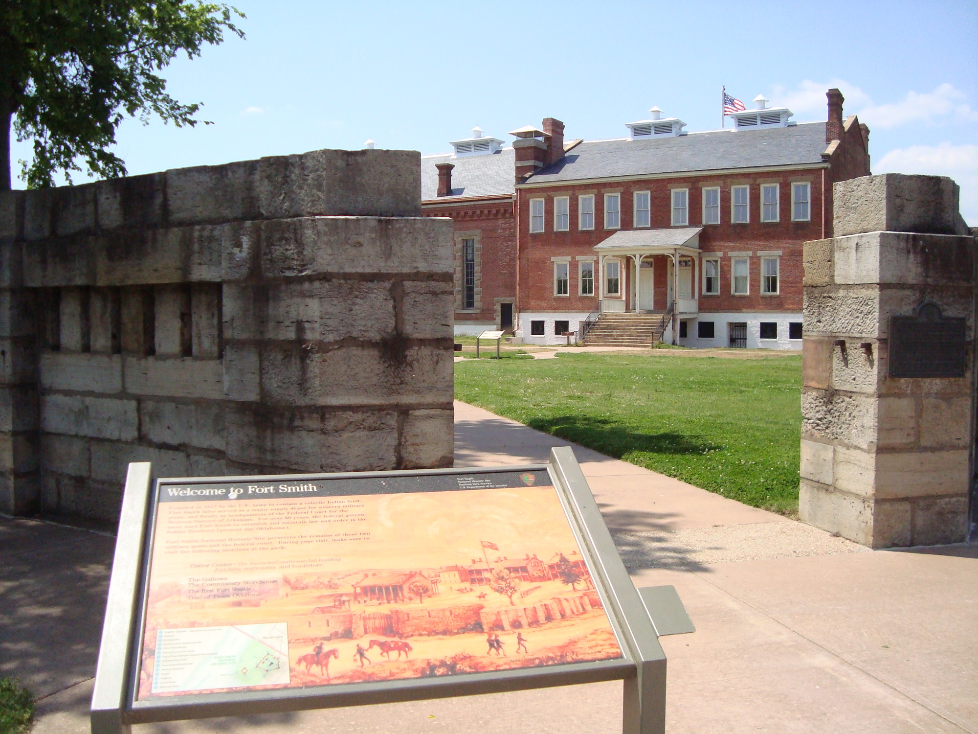 A sign in front of a large brick building.