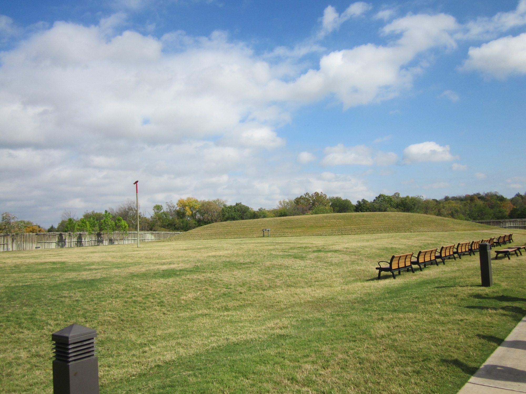 A large grassy field with benches.