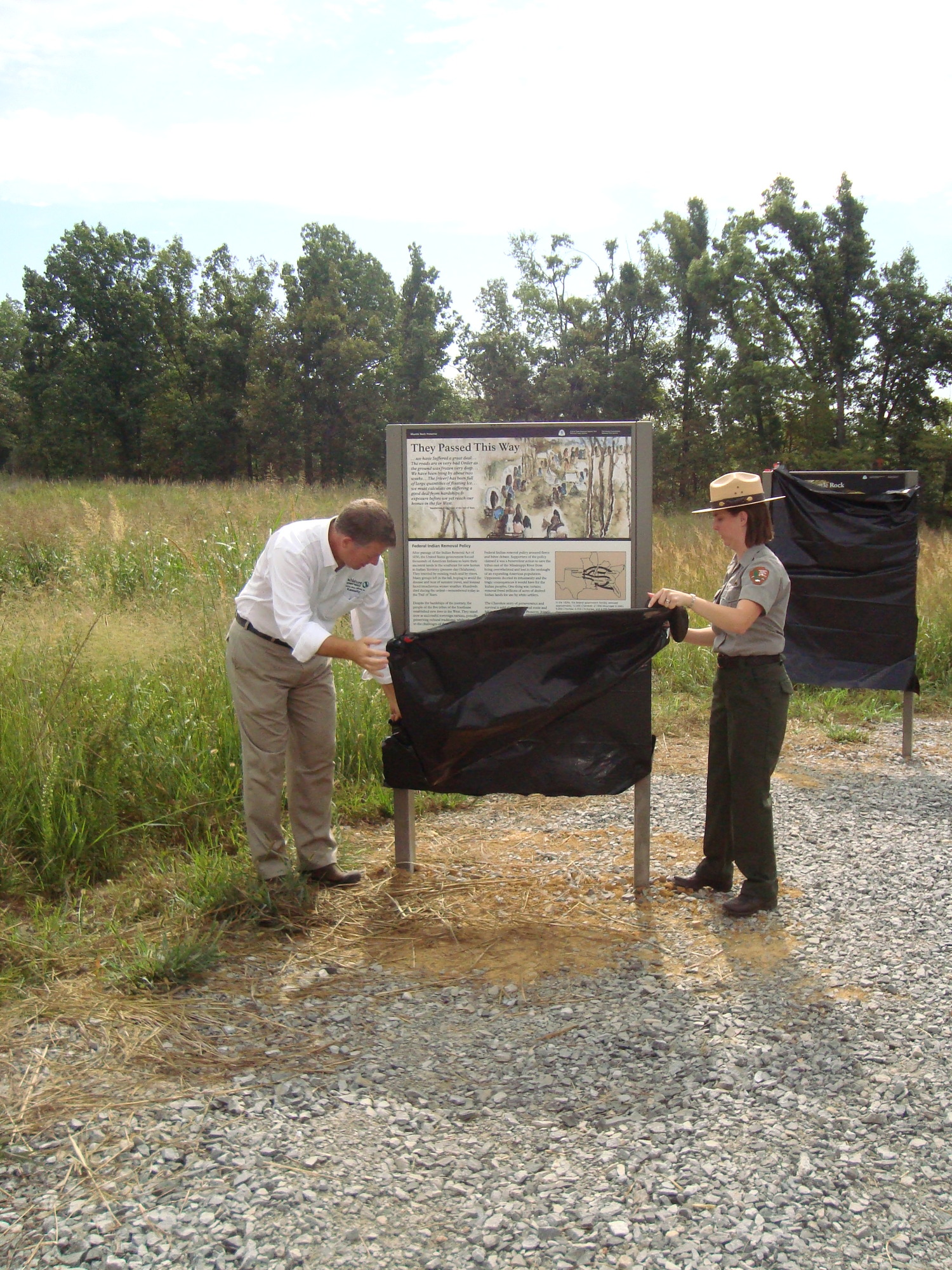 Two people standing next to a wayside.