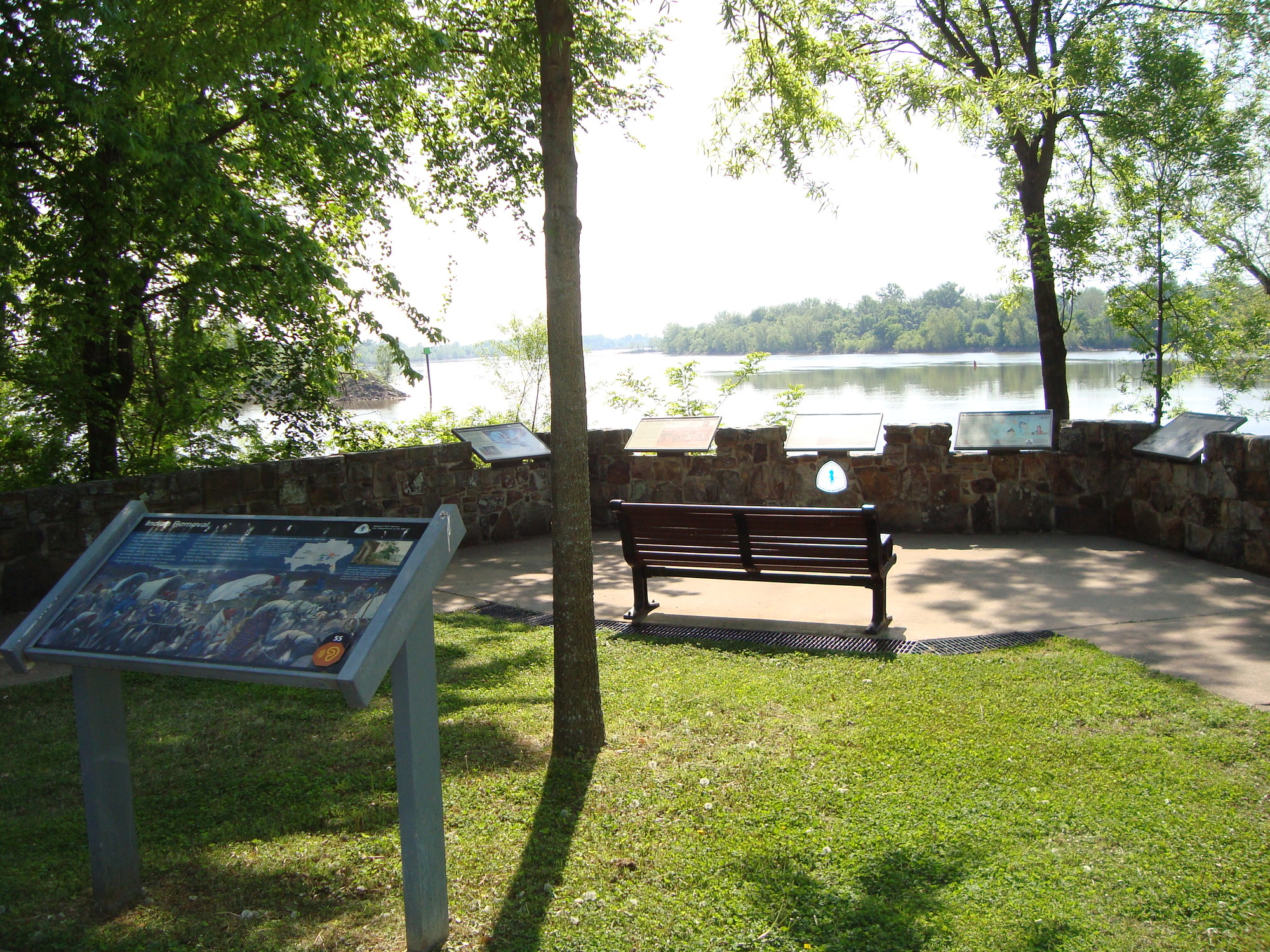 A bench in a grassy area near a body of water.