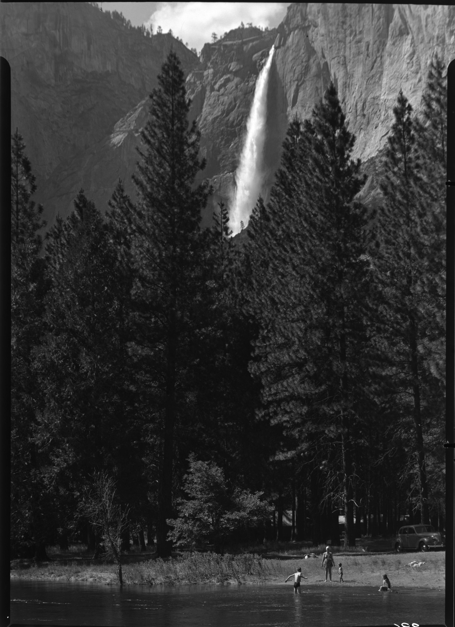 Yosemite Fall & swimmers along Merced River.