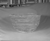 Private Collection. Object: Miwok basket. Dimensions: 18 x 10". Materials: Redbud and split willow shoots in original basket. Repairs in split maple shoots. Technology: Original basket is single rod, interlocking stitch, leftward coil direction. Repair begun on base of old basket and worked toward center until center 3 1/4", when clockspring start was stitched in to fill remainder two rows of coiling with two sewing strands at the same time, one redbud & one willow, near upper edge of original basket. Collection History: Collected by owner's mother. Murphys 1915. Photographed by Michael Dixon. Catalogued by Craig Bates and Barbara Beroza. Yosemite Collections, National Park Service.