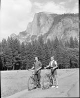 People on bicycles with Half Dome in background. For publicity.