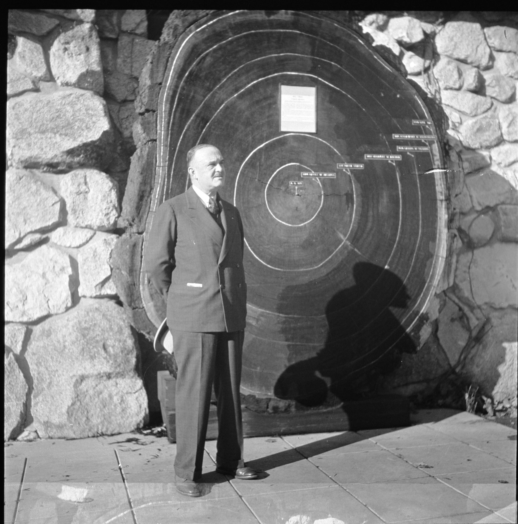 Dr. Harry C. regan, on right. He is Galen Clark's grandson. Standing at the Sequoia round in front of the Yosemite Museum building. See also RL-19,715.