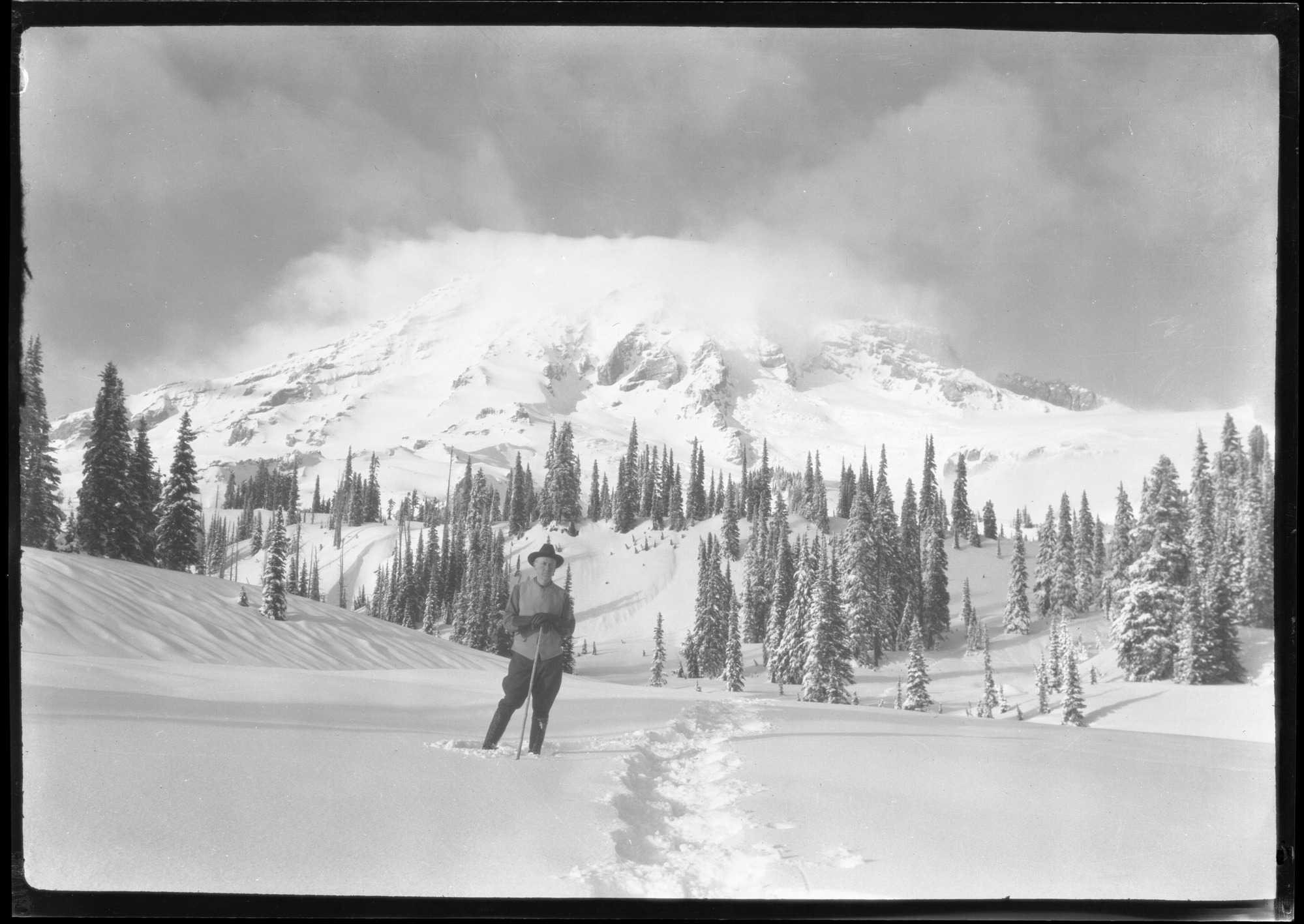 S. T. Mather on crest and ridge below Paradise, cloud cap on Mt., Mt. Rainier Park
