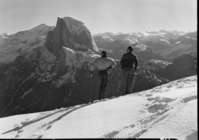Skiers at Glacier Pt. looking out over high sierra & Half Dome.