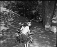 Maidu dancers running back to dressing area after dancing in the roundhouse during roundhouse dedication. Front to near: Craig Bates, Frank LaPena, Joe Marine, Brian Bibby? (in white shirt facing camera).