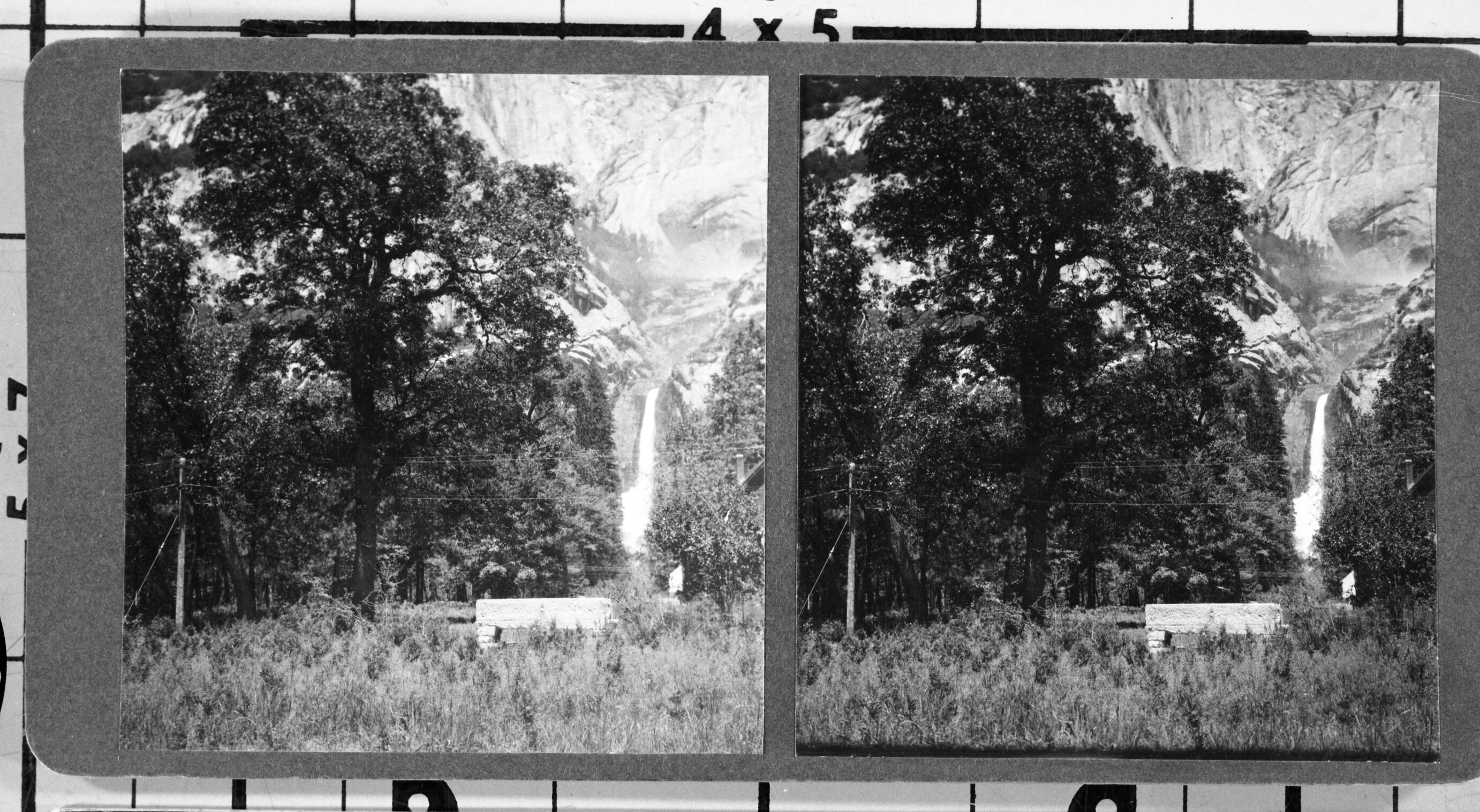 The Galen Clark memorial bench at the base of Lower Yosemite Fall. The chimney & roof on the far right were probably part of Y. P. & C. Co.'s maintenance yard.