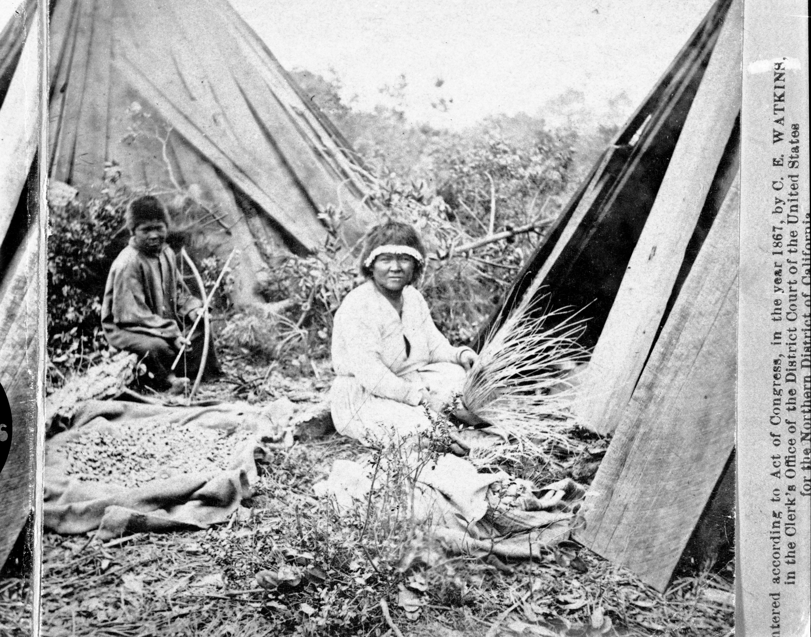 Watkins' Pacific Coast. Copy Neg: M.D. 7/24/85. Detail of L. Smaus stereo (RL-16,589). Caption: "At the Rancherio, Mendocin County, California." Woman weaving basket; boy holding bow and arrow. Acorns in bag between them, probably drying.