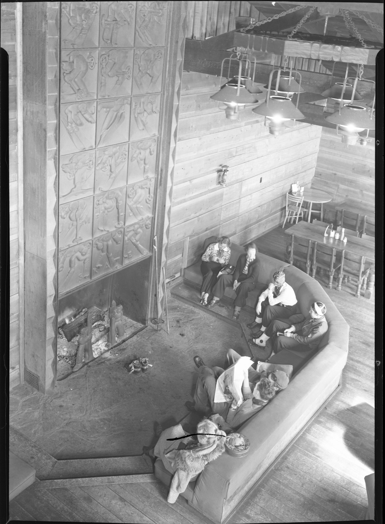 People sit gathered around fireplace