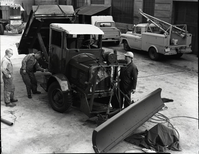 Painting FWD snow plow in maintenance area.