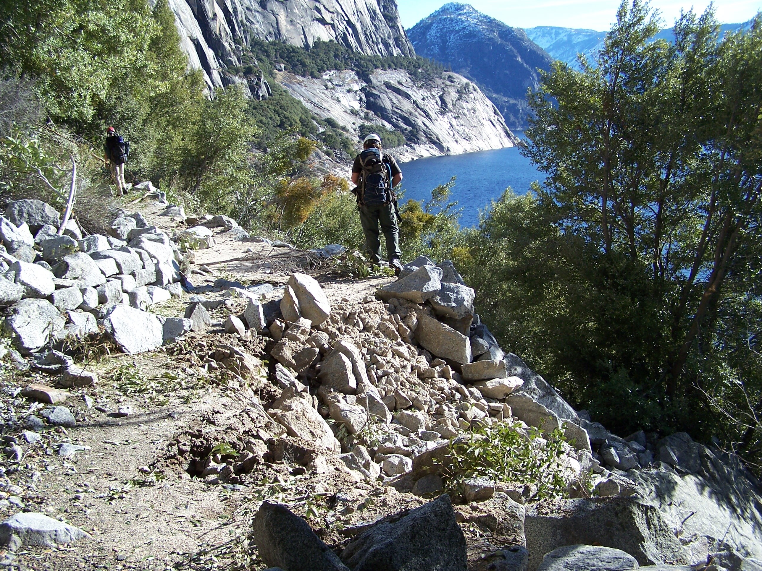 Fresh rock debris on trail. Portion of trail shows damage from the impacts of several boulders.